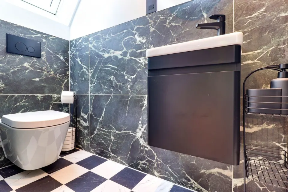 Shower room with marble effect tiles at Mead House, Bramley GU5, a Surrey Build Group project