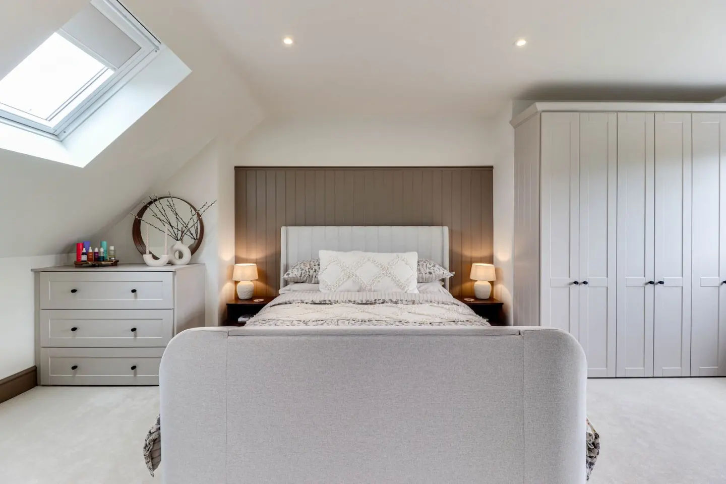 A loft bedroom with fitted wardrobes at Raeburn, Surbiton